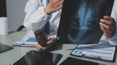 Doktor hastanın röntgen fotoğrafını tutuyor.