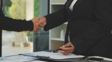 Modern bir ofiste iş adamı el sıkışıyor.