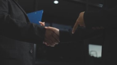 Modern bir ofiste işten sonra iş adamları el sıkışıyor..