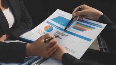 İş kadını işyerindeki belgeye işaret ediyor.