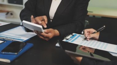 İş kadını iş yerinde elinde kalemle not defteri tutuyor.