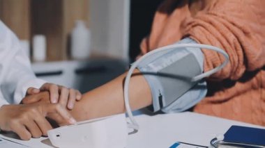 Doktor hastanedeki hastanın kan basıncını ölçüyor.