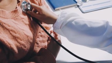 Doktor hastayla kalp atışını inceliyor.