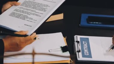 İş adamı masaya bir belge yazıyor.