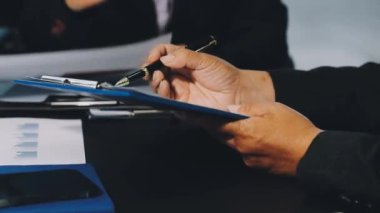 yakın plan - masa üzerine kağıt yazmak için kalem kullanan işadamı eli. business, education, technology concept