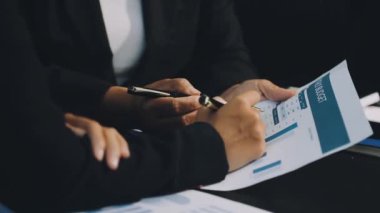 Kalem tutan işadamlarının kapatılması ve toplantı odasının arka planında sözleşme imzalanması.