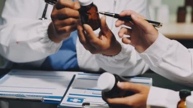 Doktorun elinde ilaç şişesi var.