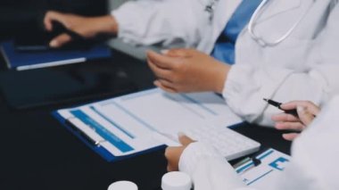 Yakın plan. Elinde şırınga ve reçeteyle hastanedeki bir hastanın ön planında duran bir erkek doktor.