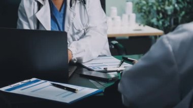 Doktor modern hastane odasındaki panoya reçete yazıyor.