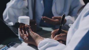 Bir şişe hap tutan erkek doktorların ellerini kapatın..