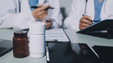 Yakın plan - Tıp doktorunun elinde hapları masanın üzerinde tutarken