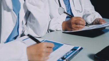 Doktor masasındaki bir panoya notlar yazıyor.