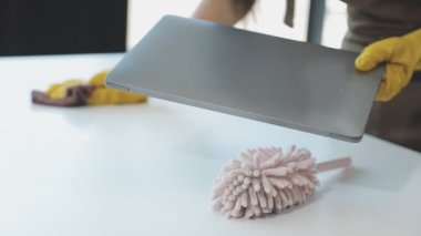 Kadın süngerle masayı temizliyor.