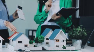 Emlakçı bir modelle ev modelini tartışıyor.