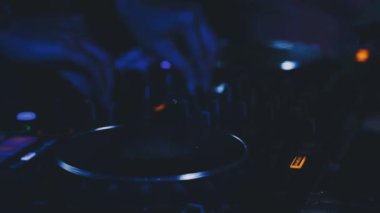Gece kulübünde bir DJ 'in elini bir kontrolörle karıştırma konsolu ile kapatıyoruz..