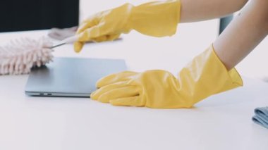 Mutfakta sarı eldivenli bir kadın.