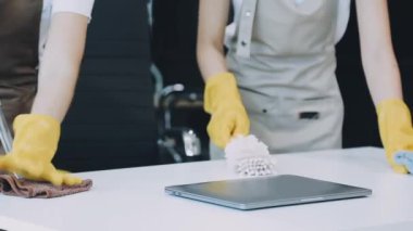 Lastik eldivenli kadın ofiste yerleri temizliyor.