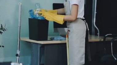 Ofisinde elektrikli süpürgesi olan bir kadın.