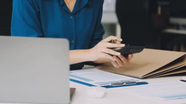 İş ekibi laptopta çalışıyor ve ofiste konuşuyor.