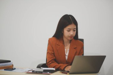 Hırslı ve kendini işine adamış genç bir profesyonel, dizüstü bilgisayarında özenle çalışırken verimliliğini ve detaylara olan ilgisini gösteriyor.