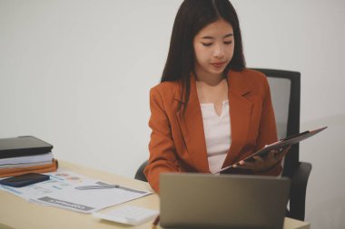 Hırslı ve kendini işine adamış genç bir profesyonel, dizüstü bilgisayarında özenle çalışırken verimliliğini ve detaylara olan ilgisini gösteriyor.
