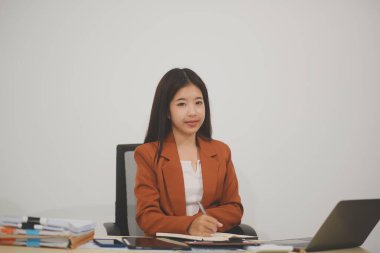 Hırslı ve kendini işine adamış genç bir profesyonel, dizüstü bilgisayarında özenle çalışırken verimliliğini ve detaylara olan ilgisini gösteriyor.