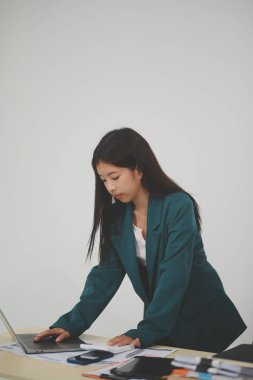 Bir ofis masası, vergi, rapor, muhasebe, istatistik ve analitik araştırma kavramında matematik finansmanı için hesap makinesi ve dizüstü bilgisayar kullanan Asyalı İş kadını