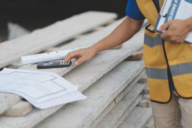 Genç yakışıklı Asyalı inşaat mühendisi elinde tabletle ileriye bakıyor ve düşünüyor, inşaat geçmişini planlıyor. Evrim inşa kavramı.