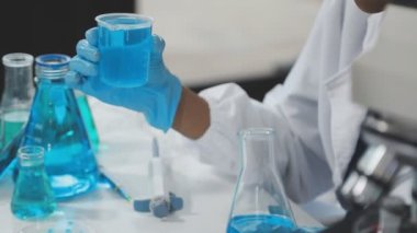 Laboratuvardaki bilim adamı kimyasal test tüpüyle çalışıyor..