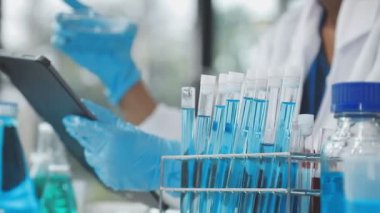 Laboratuvarda tüplerle çalışan bilim adamı.