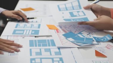 Mimarlardan oluşan bir ekip ofiste plan üzerinde çalışıyor.