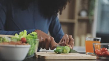 Kadın ev mutfağında sağlıklı sebze salatası pişiriyor..