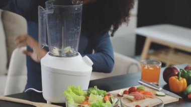 Genç bayan mutfakta taze meyve püresi hazırlıyor.