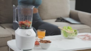 Kadın eli mutfakta sağlıklı smoothie yapıyor.