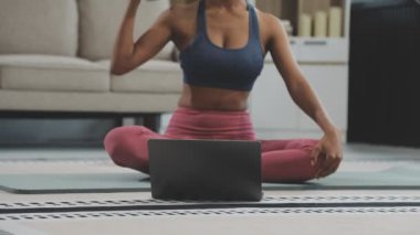 Güzel bir kadın yoga yapıyor ve laptopta yoga yapıyor. ev fitness, yoga, online yaşam tarzı.