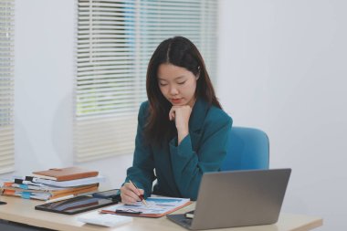 Şirket ofisinde tablet bilgisayarda çalışan Asyalı profesyonel iş kadını.