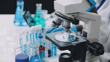 Bulanık arkaplanda laboratuvar mikroskobu ve test tüplerini kapat.