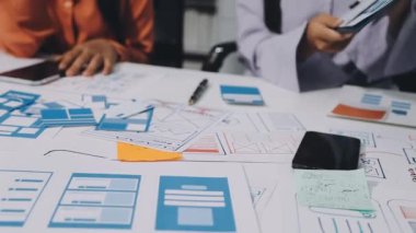 İş adamları, çalışma masasındaki çizelgelerle tartışıyor.