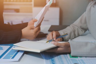 İş adamlarından oluşan bir ekip, pazarlama planı, piyasa araştırma raporları ve gelir istatistikleri, Mali ve Muhasebe kavramının verilerini analiz etmek üzere toplanıyor..