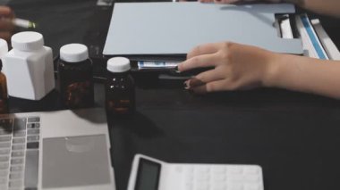 Doktor hastane ofisinde tablet üzerinde çalışıyor.