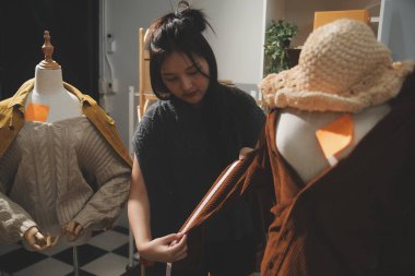 Moda tasarımcıları iş başında. Moda tasarım stüdyosunda çalışan güzel genç bir kadın..