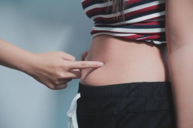 Kadın göbeği. Şişman kadın göbek yağlarını tutuyor. diyet yaşam tarzı konsepti karın kaslarını zayıflatmak ve sağlıklı mide kaslarını şekillendirmek için.
