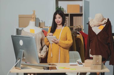 Moda tasarımcıları iş başında. Moda tasarım stüdyosunda çalışan güzel genç bir kadın..