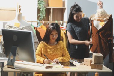 Moda tasarımcıları iş başında. Moda tasarım stüdyosunda çalışan güzel genç bir kadın..