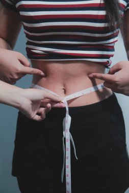 Kadın göbeği. Şişman kadın göbek yağlarını tutuyor. diyet yaşam tarzı konsepti karın kaslarını zayıflatmak ve sağlıklı mide kaslarını şekillendirmek için.