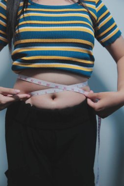 Kadın göbeği. Şişman kadın göbek yağlarını tutuyor. diyet yaşam tarzı konsepti karın kaslarını zayıflatmak ve sağlıklı mide kaslarını şekillendirmek için.