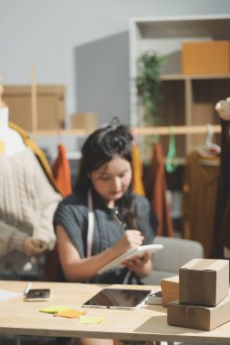 Moda tasarımcıları iş başında. Moda tasarım stüdyosunda çalışan güzel genç bir kadın..