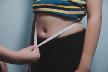 Kadın göbeği. Şişman kadın göbek yağlarını tutuyor. diyet yaşam tarzı konsepti karın kaslarını zayıflatmak ve sağlıklı mide kaslarını şekillendirmek için.