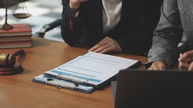 Avukat ofiste evraklarla çalışıyor, avukat müvekkil ile çalışıyor.