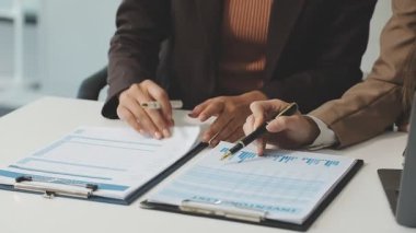 İş kadını ve yönetici ofiste belgeleri tartışıyor.